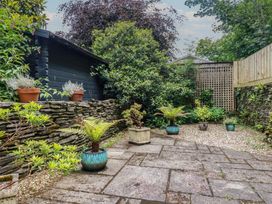 A garden with stone wall and potted plants at Stowaway Cottage in Padstow