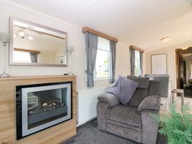 A living room with a fireplace and furniture at 18 Eden Heights in St Andrews
