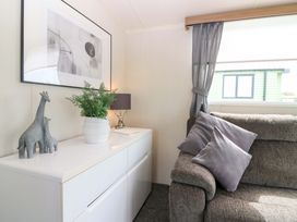 A living room with a sofa, lamp, and artwork at 18 Eden Heights in St Andrews