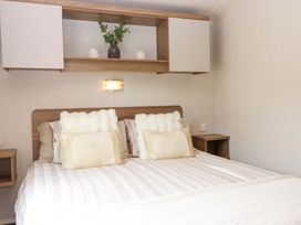 A bedroom with a bed and shelf at 18 Eden Heights in St Andrews