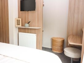 A bedroom with a television and shelf at 18 Eden Heights in St Andrews