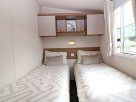 A bedroom with two single beds and a shelf at 18 Eden Heights St Andrews