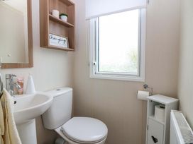 A bathroom with a sink, toilet, and window at 18 Eden Heights St Andrews