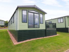 A mobile home with windows and a deck at 18 Eden Heights St Andrews
