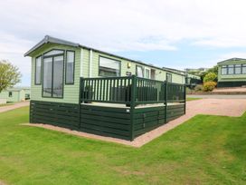 A holiday home with decking and grass at 18 Eden Heights St Andrews