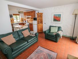 A living room with a sofa and armchair at Swallow Cottage in Cowbridge