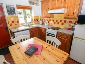 A kitchen with wooden furniture and appliances at Swallow Cottage in Cowbridge