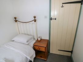 A bedroom with a bed and a nightstand at Swallow Cottage in Cowbridge