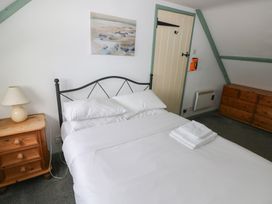 A bedroom with a bed and nightstand at Swallow Cottage in Cowbridge
