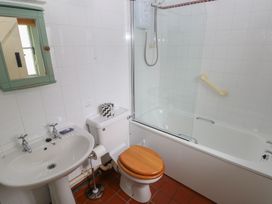 A bathroom with a bathtub, washbasin, and toilet at Swallow Cottage in Cowbridge