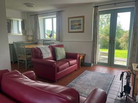 A living room with a sofa and dining table at Wren Cottage in Cowbridge