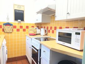 A kitchen with a microwave and kettle at Wren Cottage in Cowbridge