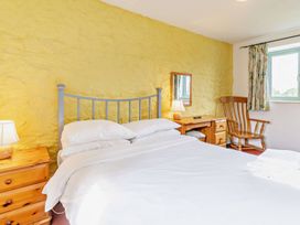 A bedroom with a bed and nightstand at Wren Cottage in Cowbridge
