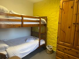 A bedroom with a bunk bed and a single bed at Wren Cottage in Cowbridge