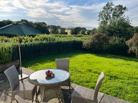 A garden with a table and chairs at Wren Cottage in Cowbridge
