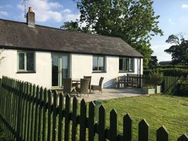 A house with a patio and furniture at Wren Cottage in Cowbridge