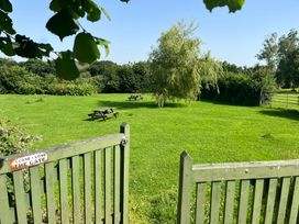 A garden with picnic tables and a gate at Wren Cottage in Cowbridge