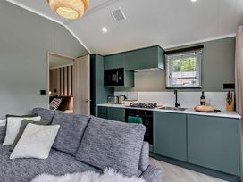 A kitchen with cabinets and a sofa at Prion 1.0 Pet in Llandyrnog