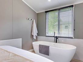 A bathroom with a bathtub and towel at Prion 1.0 Pet in Llandyrnog