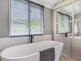 A bathroom with a bathtub and a window at Prion 1.0 Pet in Llandyrnog