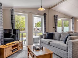 A living room with a sofa and television at Elwy 3.0 Pet in Llandyrnog