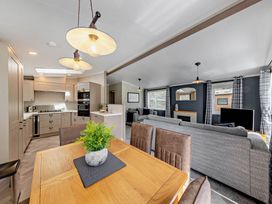 A living room and kitchen area with a dining table and modern appliances at Elwy 3.0 Pet in Llandyrnog