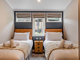A bedroom with two beds and a nightstand at Elwy 3.0 Pet in Llandyrnog