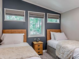 A bedroom with two beds and windows with blinds at Elwy 3.0 Pet in Llandyrnog