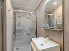 A bathroom featuring a shower, sink, and mirror at Elwy 3.0 Pet in Llandyrnog