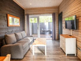A living room with a sofa, coffee table, and television at Pine Lodge Spa Carlton Miniott near Thirsk