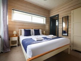 A bedroom with a bed and bedside table at Pine Lodge Spa Pet in Thirsk