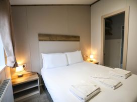 A bedroom with a bed and bedside table at Laurel Waterside Spa Carlton Miniott near Thirsk