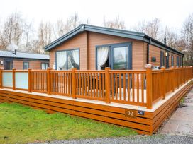 A house with decking and a railing at Laurel Waterside Spa Carlton Miniott near Thirsk
