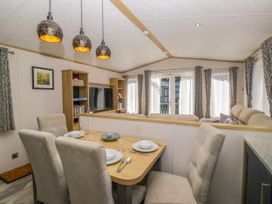A dining room with a table set for dinner at 51 Calgarth Park Troutbeck