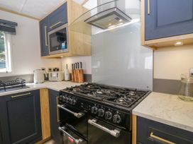 A kitchen with an oven and microwave at 51 Calgarth Park in Troutbeck