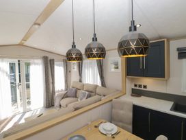 A living room with a sofa and dining table at 51 Calgarth Park in Troutbeck