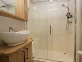 A bathroom with a shower and sink at 51 Calgarth Park in Troutbeck