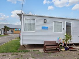 A caravan with a bench and flower pot at Beachcomber in Rhyl