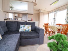 A living room with a sofa and dining area at 15 Cherry Tree walk in Rhyl