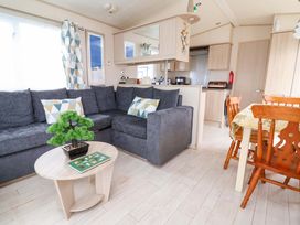 A living room with a sofa and dining area at 15 Cherry Tree walk Rhyl