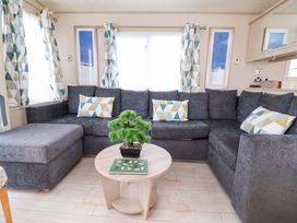 A living room with a sofa and table at 15 Cherry Tree walk Rhyl