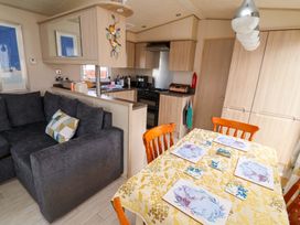 A living room with a sofa and dining area at 15 Cherry Tree walk in Rhyl
