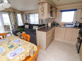 A living room and kitchen area with a dining table at 15 Cherry Tree walk in Rhyl