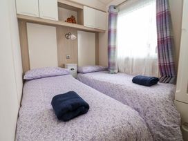 A bedroom with two beds and a bedside table at 15 Cherry Tree walk, Rhyl
