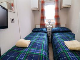 A bedroom with two beds and a lamp at 15 Cherry Tree walk in Rhyl