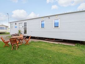 A mobile home with a table and chairs outside at 15 Cherry Tree walk Rhyl