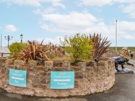 A decorative stonewall with plants and signs in Prestatyn