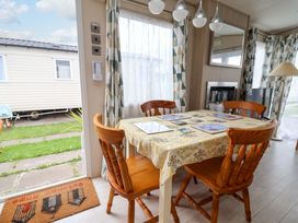 A dining room with a table and chairs at 15 Cherry Tree walk in Rhyl