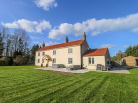 A house with a lawn and patio at Tuft House in Hovingham