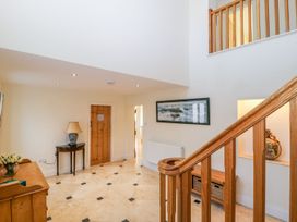 A hallway with a staircase and a table at Tuft House in Hovingham